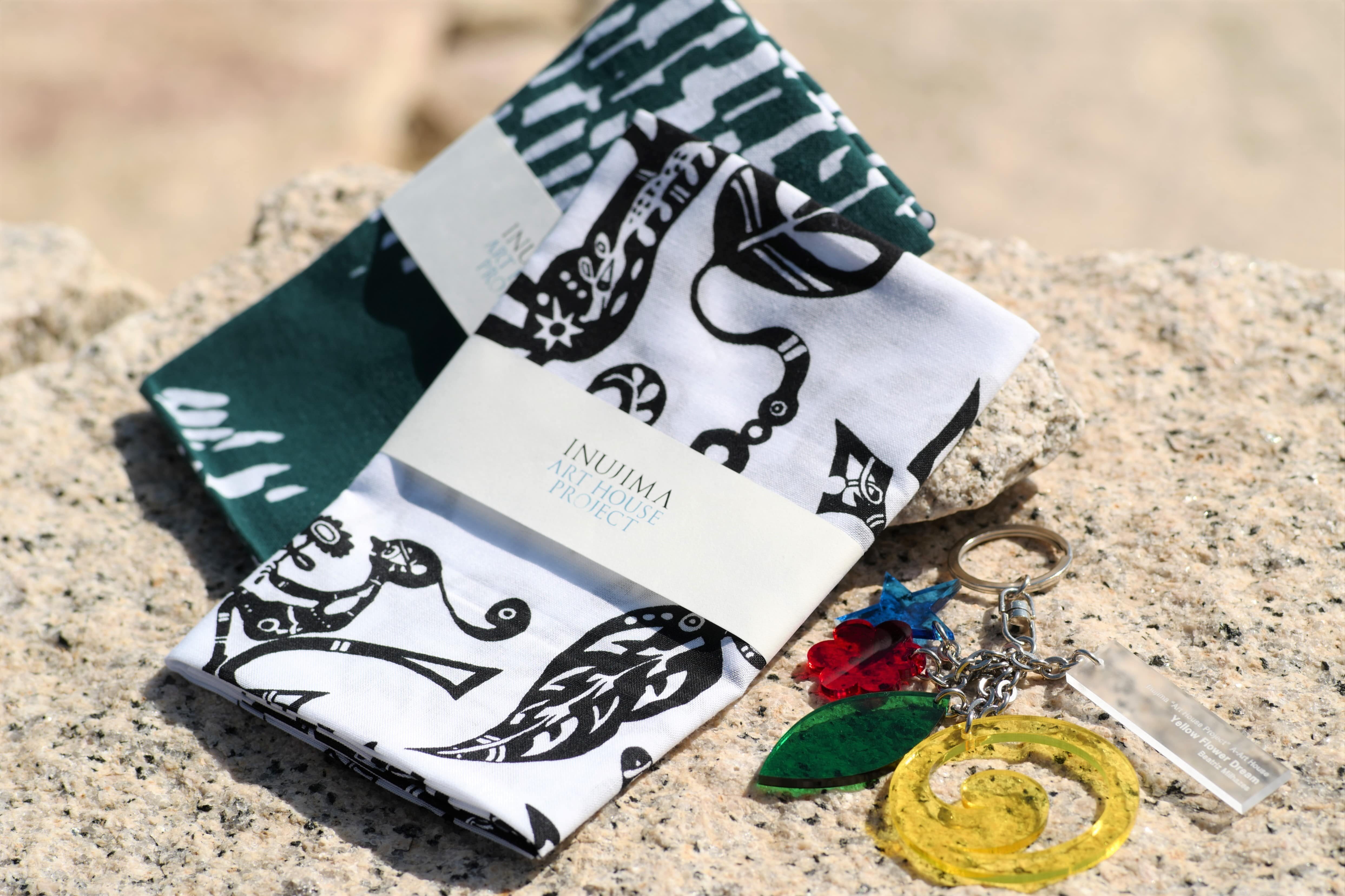 (L) Inujima  " Art House Project " Masanori Handa Design Towel ¥1,430 (tax included)<br>Inujima  " Art House Project " Yusuke Asai Design Towel ¥1,430 (tax included)<br>(R) Inujima  " Art House Project " Beatriz Key Ring ¥2,420 (tax included)